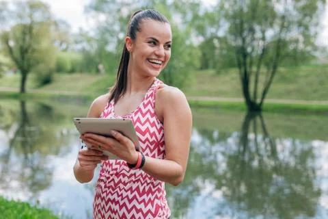 Girl is using tablet pc. She has a break in workout. Stock Photos