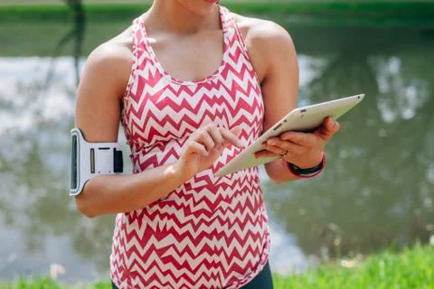 Girl is using tablet pc. She has a break in workout. Close up. Stock Photos