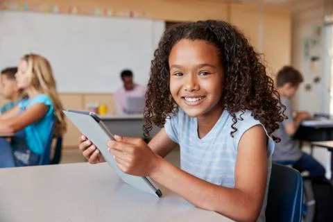 Girl using tablet in school class smiling to camera close up 스톡 사진