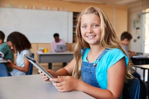 Girl using tablet in school class smiling to camera close up 스톡 사진