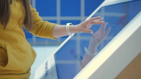 Girl using a touch terminal in a shopping mall. The concept of people and Stock Footage 252874177