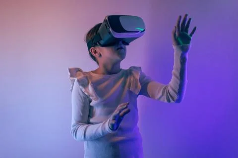 Girl using virtual reality headset interacting with digital environment und.. Stock Photos