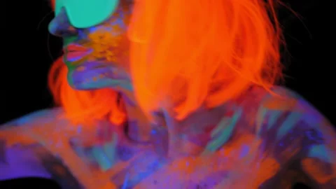 A girl with an UV pattern on her face, wearing an orange wig and green glasses Stock Footage 153168061