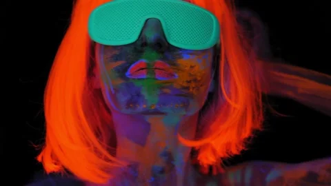 A girl with an UV pattern on her face, wearing an orange wig and green glasses Stock Footage 197014739