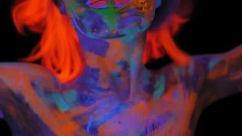 A girl with an UV pattern on her face, wearing an orange wig and green glasses Stock Footage 197348327