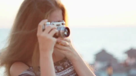 Girl with a vintage camera. Beach, sunset, wind Stock Footage