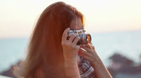 Girl with a vintage camera. Beach, sunset, wind Stock Footage
