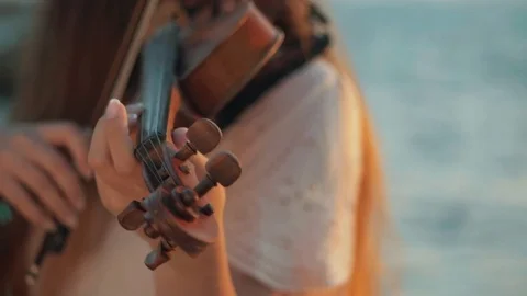 Girl violinist playing the violin outdoors. Green leaves backgound. Close up Stock Footage