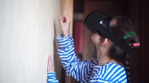 Girl in virtual reality glasses knocks on the wall playing in the builder Stock Footage 125462229