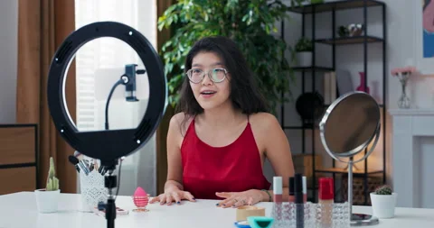 Girl vlogger is recording makeup tutorial video for watchers for channel, waving 動画素材 196219379
