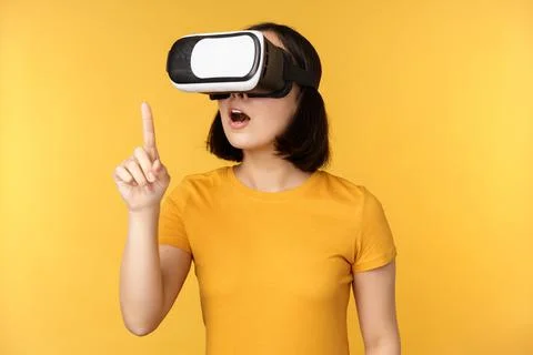 Girl in VR. Beautiful young asian woman, using virtual reality glasses and Stock Photos