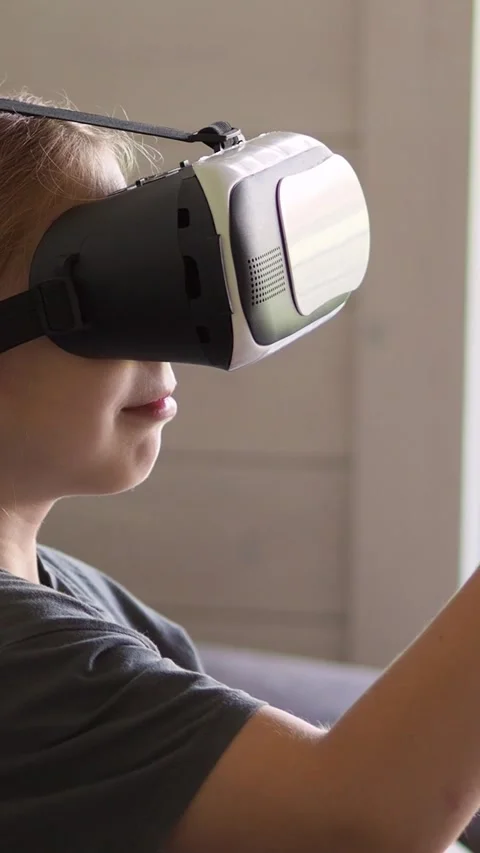 A girl in VR glasses side view, reads a virtual book, turns the page, enlarges t Stock Footage 314047376