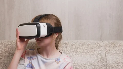 Girl in VR headset sitting on sofa Vidéo 104104553