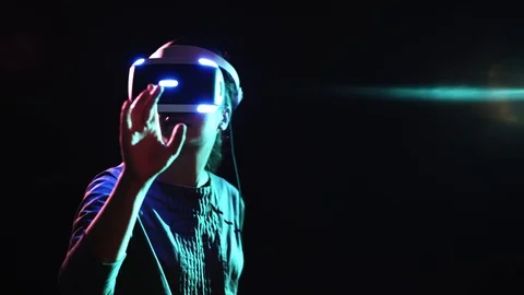 Girl in VR headset touching virtual screen in dark space Video stock 103637763
