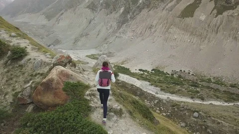 Girl walking along narrow summit ridge crest in the evening Stock Footage 80778002