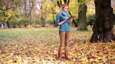 Girl walking and using tablet in the park 스톡 동영상 44789396