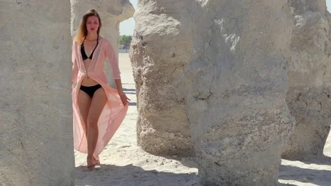 Girl walking between columns of sand Stock Footage 76181509