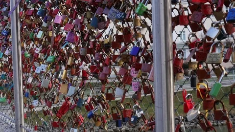 Girl walking on the bridge full of locks. Video stock 80958022
