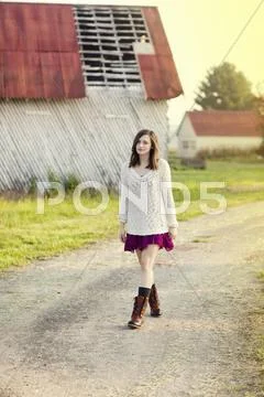Girl walking on dirt path in rural farm Stock Photos