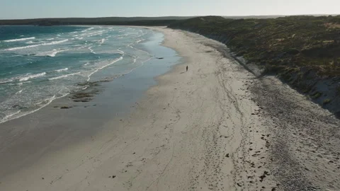 Girl walking on an empty beach drone video Stock Footage 241838386