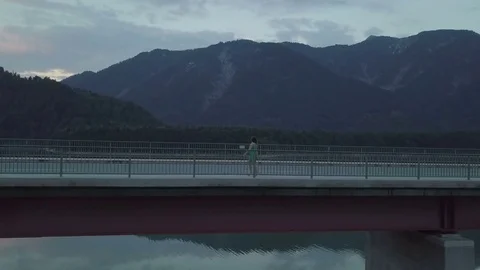 Girl is walking on the empty bridge in the sunset time - Aerial Stock Footage 83752030