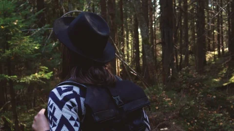 Girl walking in the forest. Sun rays. Authentic poncho and black hat. Ukraini Video stock 120341925