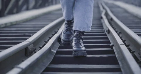 The girl is walking on the railway. Walks on the bridge over the water. Stock Footage