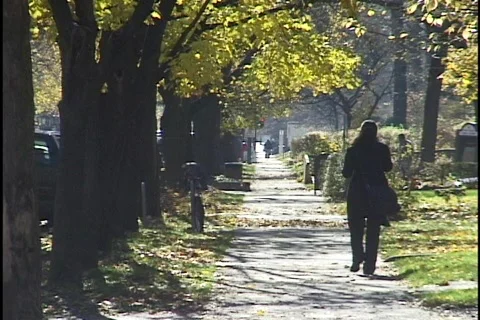 Girl Walking on Sidewalk in the Fall Stockbeeldmateriaal 297616