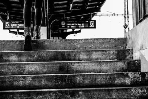 Girl walking up the stairs at the railway station Stock Photos