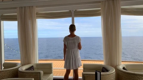 Girl walking through viewing deck on luxury cruise with cocktail in hand 库存影片 98528534