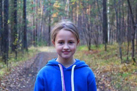A girl walks alone while walking through the forest on an autumn day. Loneliness Stock Photos