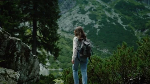 The girl walks with a backpack against the background of mountains Stock Footage 205741379