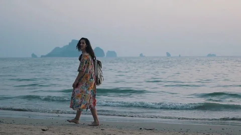 Girl walks with a backpack by the ocean Stock Footage 106343096