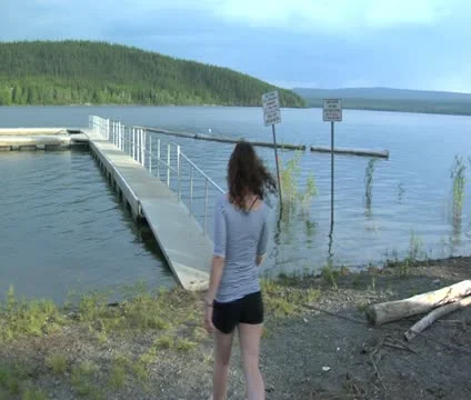 Girl walks down dock Video stock 21899655