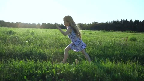 A girl walks on the grass in the rays of the setting summer sun. doing gymnastic Stock Footage 168223672