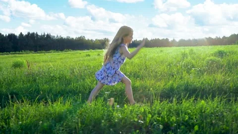 A girl walks on the grass in the rays of the setting summer sun. doing gymnastic Stock Footage 168510665