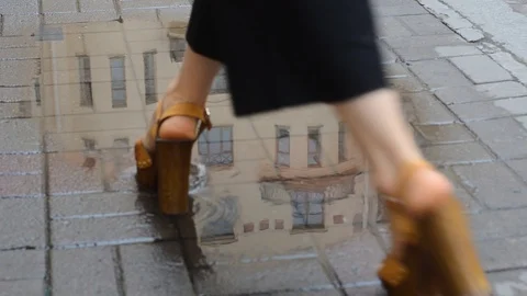 Girl walks through a puddle which reflects the house Stock Footage 101154506