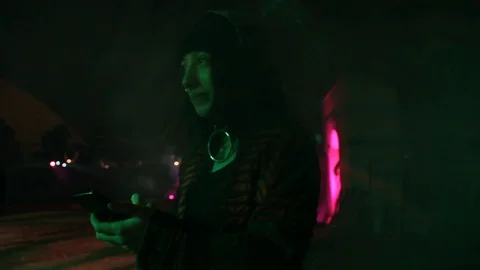 Girl wanders around Halloween theme park, while on phone Stock Footage 83131153