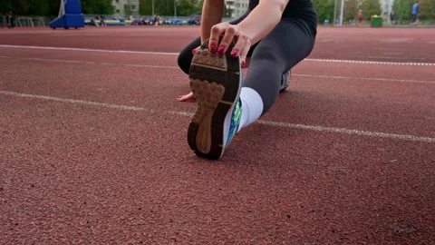 Girl warming up before running Stockbeeldmateriaal 253186189