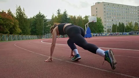 Girl warming up before running Stockbeeldmateriaal 253186281