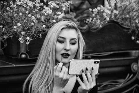 Girl watching makeup tutorial video. Lipstick on lips. Cosmetics and makeup. Get Fotos Stock