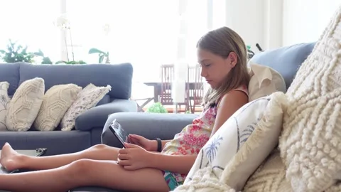 Girl watching a tablet sitting on the sofa.mp4 Stock Footage 284670322