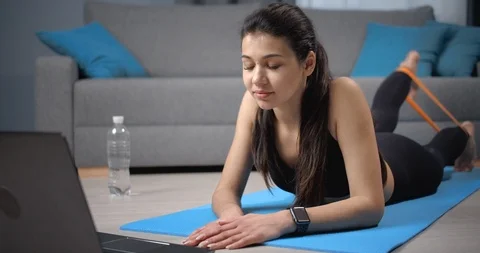 Girl watching tutorial course on laptop about home workout Stockbeeldmateriaal 124296561