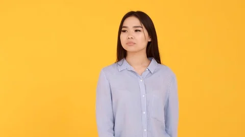 The girl waves her hands at camera. joy meeting . woman on yellow background Stock Footage 125930308