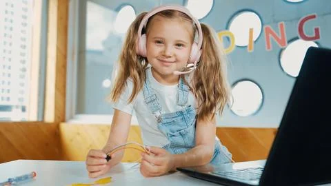 Girl wearing headphone while study equipment and looking at camera. Erudition. Stock Photos