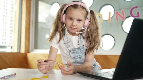 Girl wearing headphone while study equipment and looking at camera. Erudition. Stock Photos