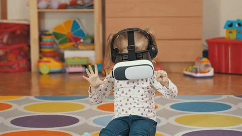Girl wearing virtual reality goggles. Virtual reality game. The little girl w Stock Footage