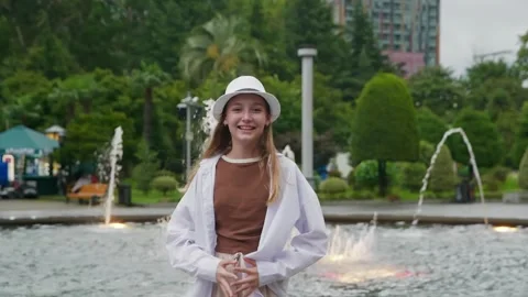 Girl wearing white hat posing near fountain in urban park Stock-Footage 342087583