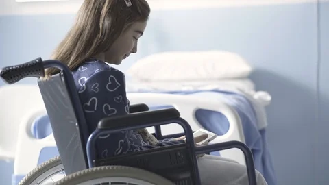 Girl in wheelchair using a digital tablet at the hospital Stock Footage 128794202