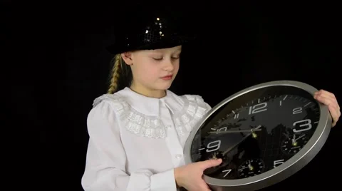 Girl in a white dress on a black background with a clock showing the time. We Stock Footage 59448207